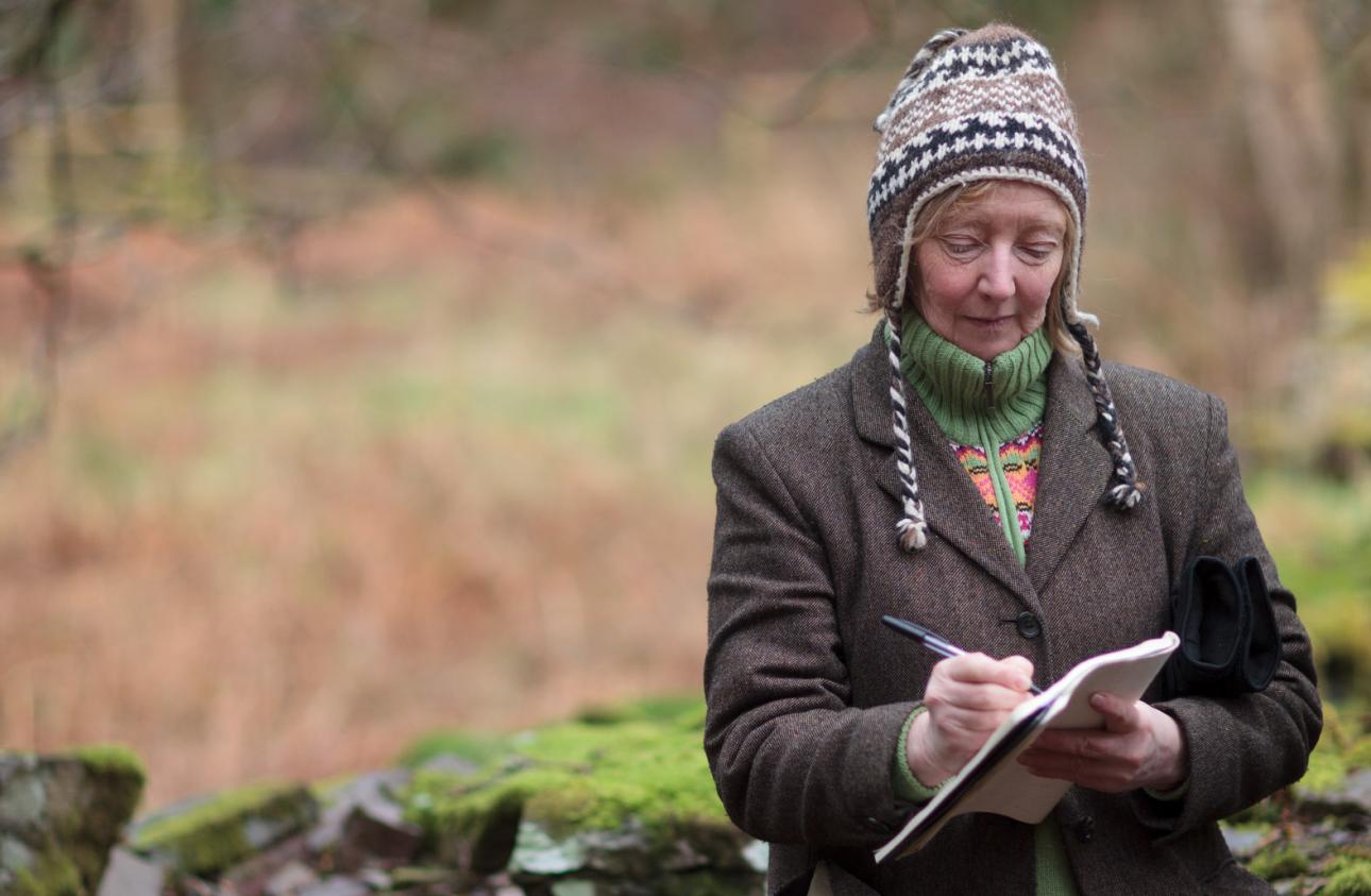 Lynne Denman making notes outdoors 