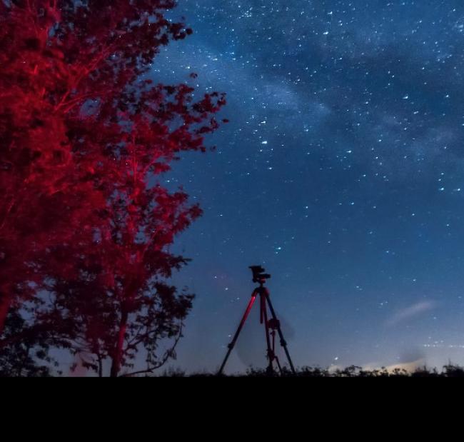 A tripod with the night sky in the background